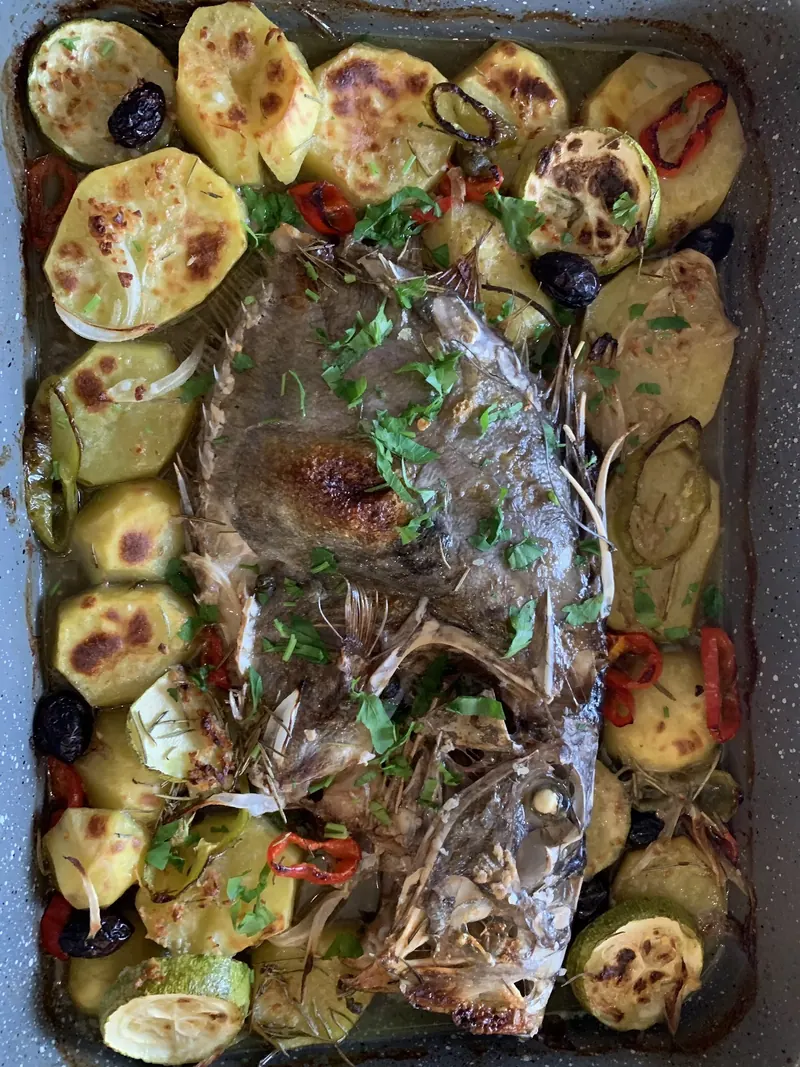 Fish baked in a tray with potatoes and courgette