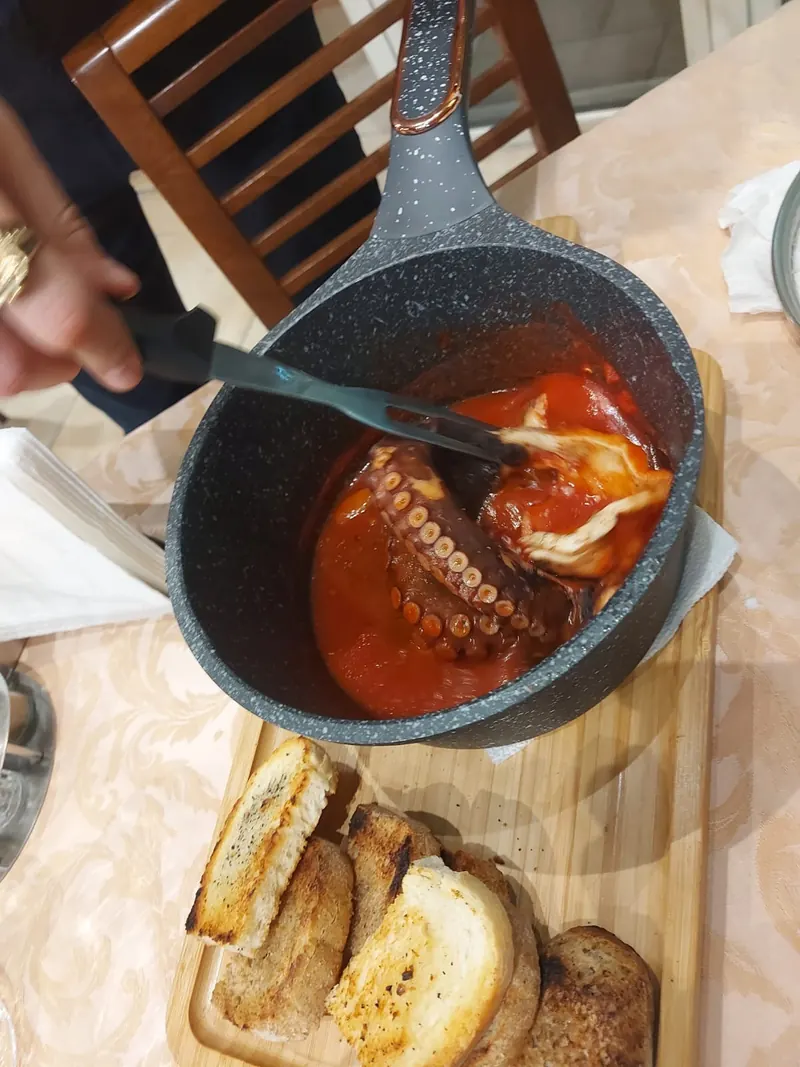 Octopus in tomato sauce served from the pan with toasted bread
