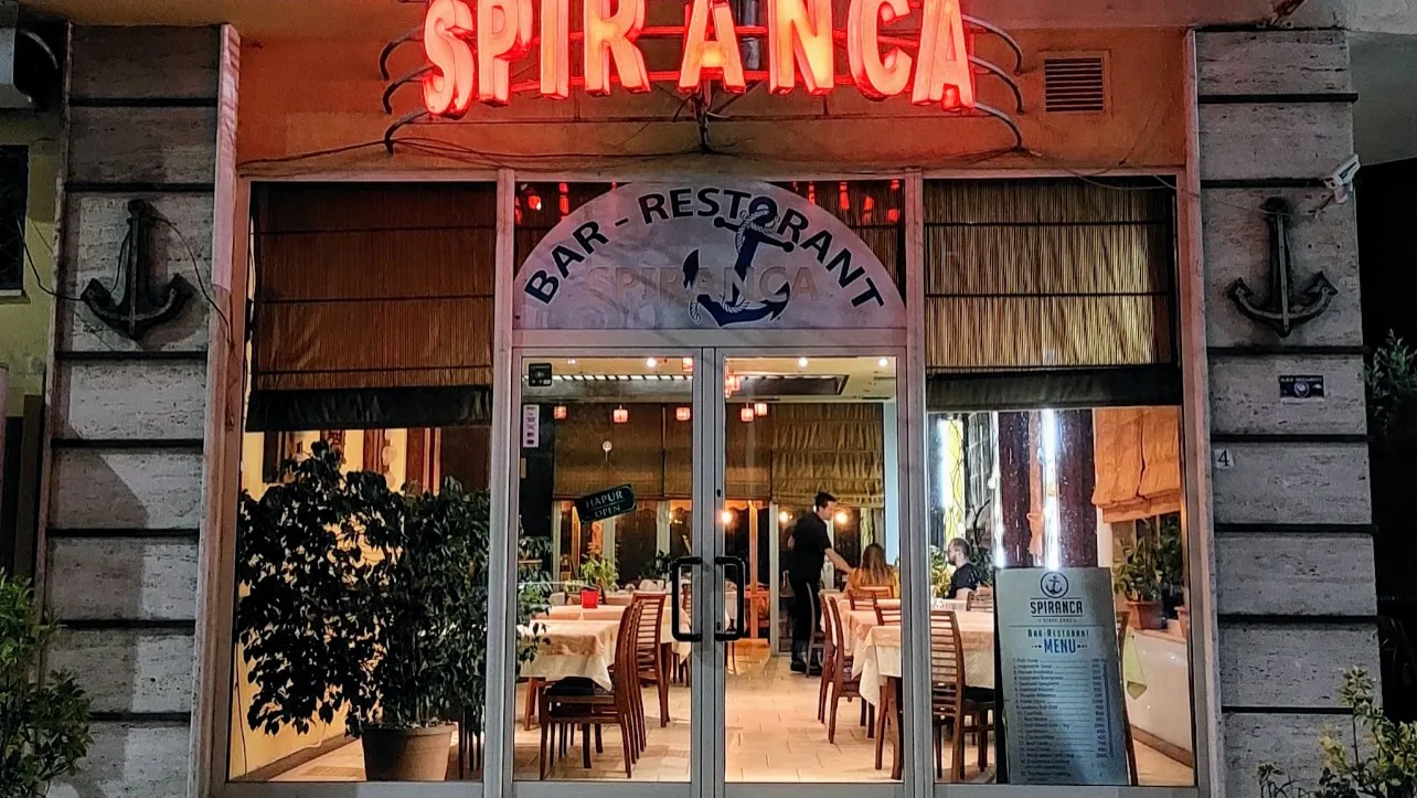 The red neon Spiranca sign above the restaurant entrance at night
